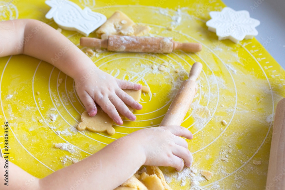 Cute little girl with rolling pin preparing Christmas cookies