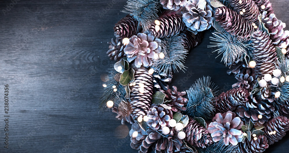 Christmas holiday background. Xmas wreath with spruce, cones and lights. Christmas decoration border