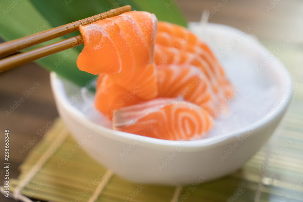 筷子配三文鱼生鱼片三文鱼生鱼片冰上碗。亚洲餐厅的日本菜