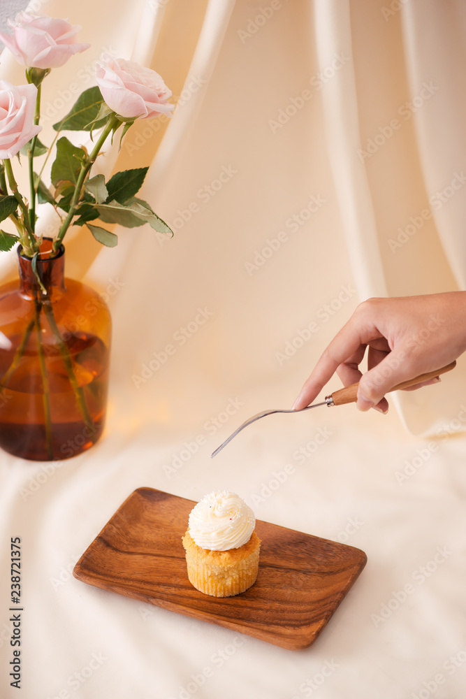 女性手切桌上美味的纸杯蛋糕