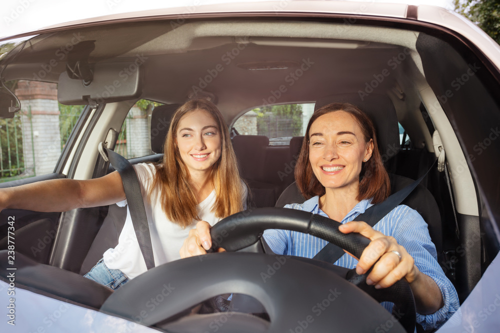 Mother driving with daughter on passenger seat