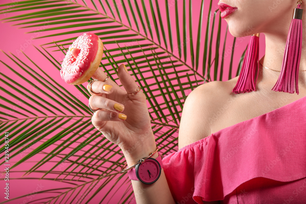 美丽时尚的女人，彩色背景上有美味的甜甜圈