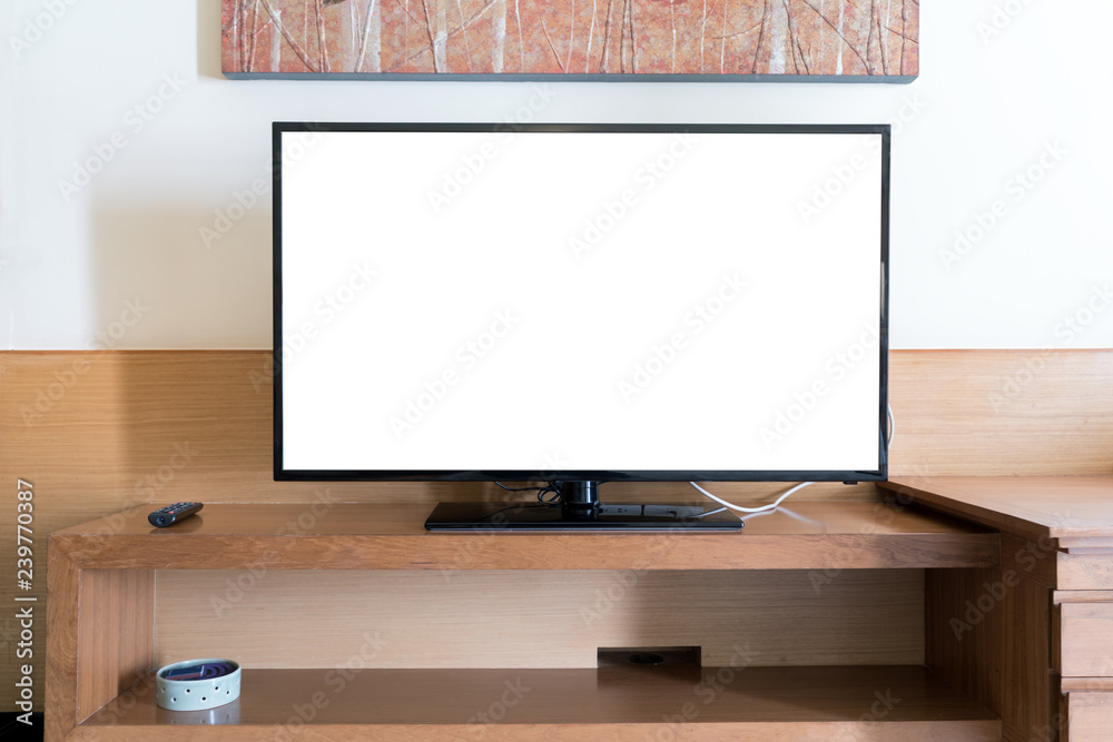 家里客厅wwden架子上的带遥控面板的实体平板电视屏幕。