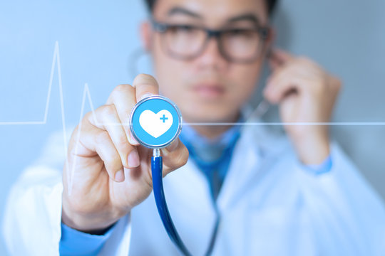 Medic doctor hold stethoscope in hand show icon medical network connection with modern heart rate virtual screen interface in hospital, medical technology communication network to help patient concept