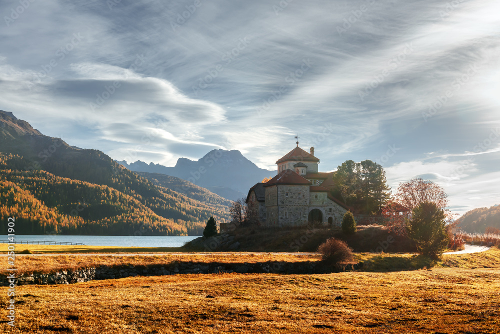 Amazing autumn sunny day at Champferersee lake in the Swiss Alps. Castle of Crap da Sass, Silvaplana