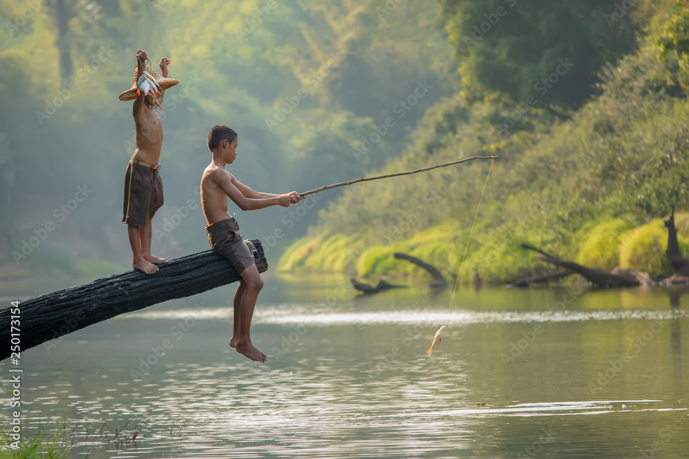 生活在越南农村的贫困儿童在河边捕鱼，亚洲的农村概念