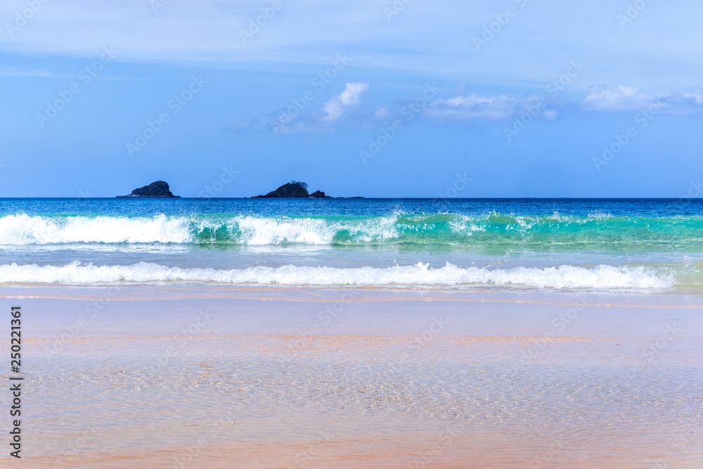 美丽而神奇的金色沙滩，柔软的海浪与晴朗的蓝天隔离。概念