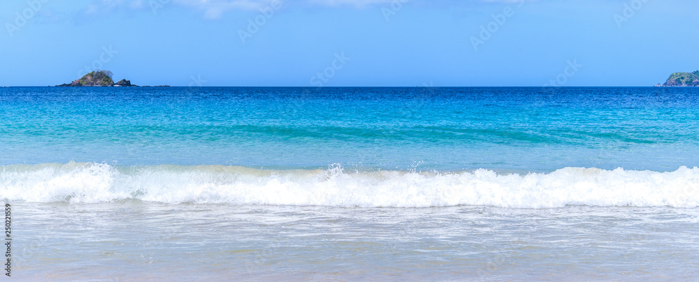 美丽迷人的金色沙滩，柔软的海浪与晴朗的蓝天隔离。概念