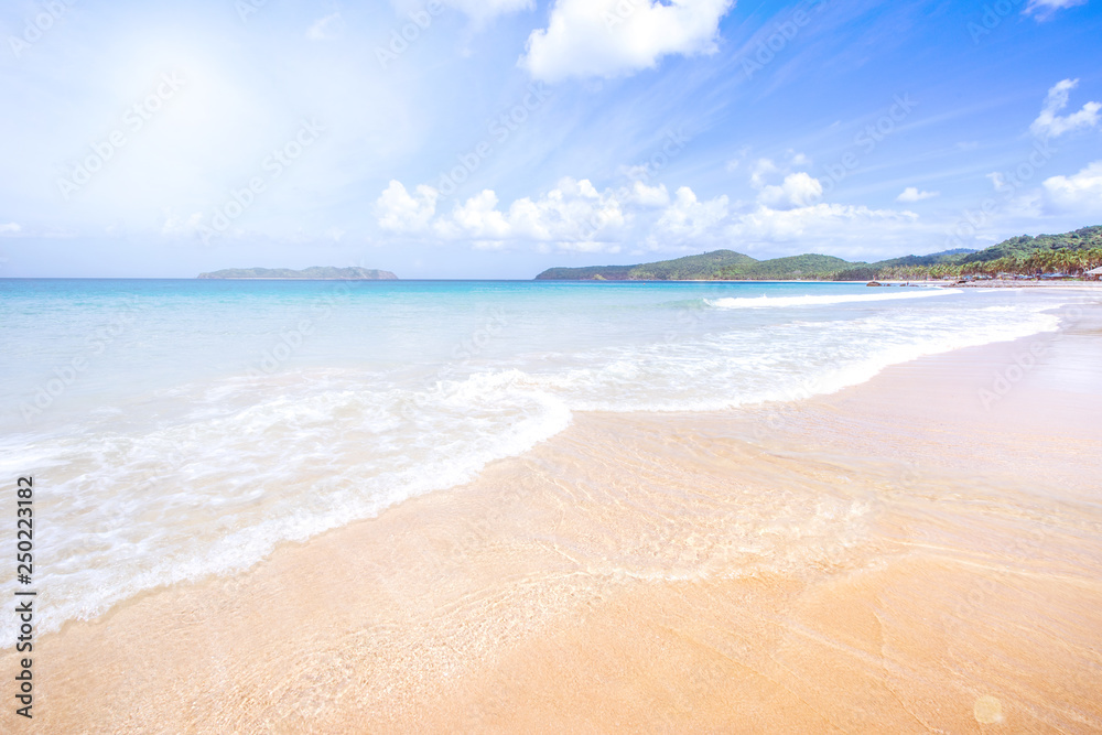 美丽迷人的金色沙滩，柔软的海浪与阳光明媚的蓝天隔离。概念