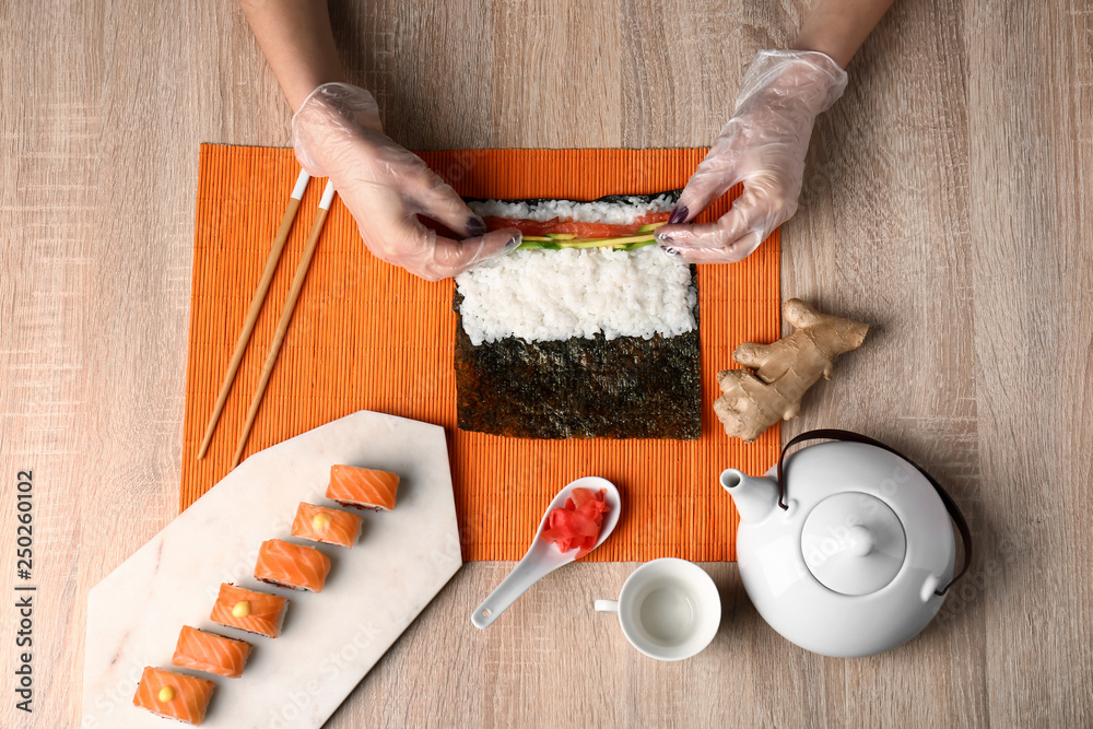 女人在餐桌上做美味的寿司卷