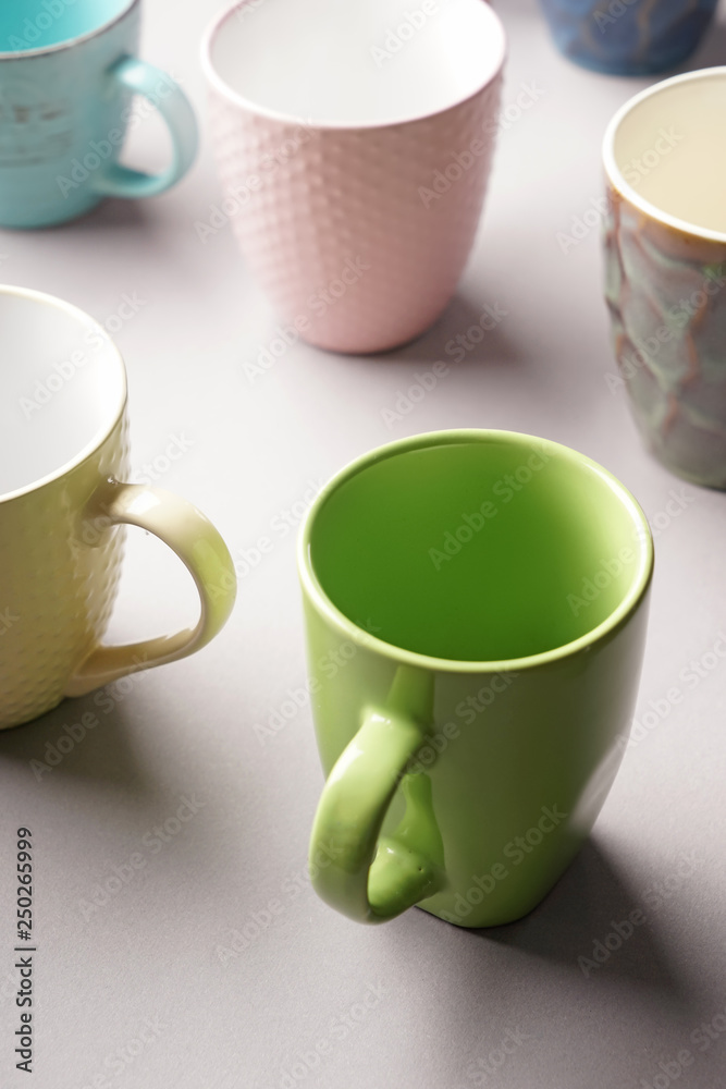 Colorful empty cups on light background