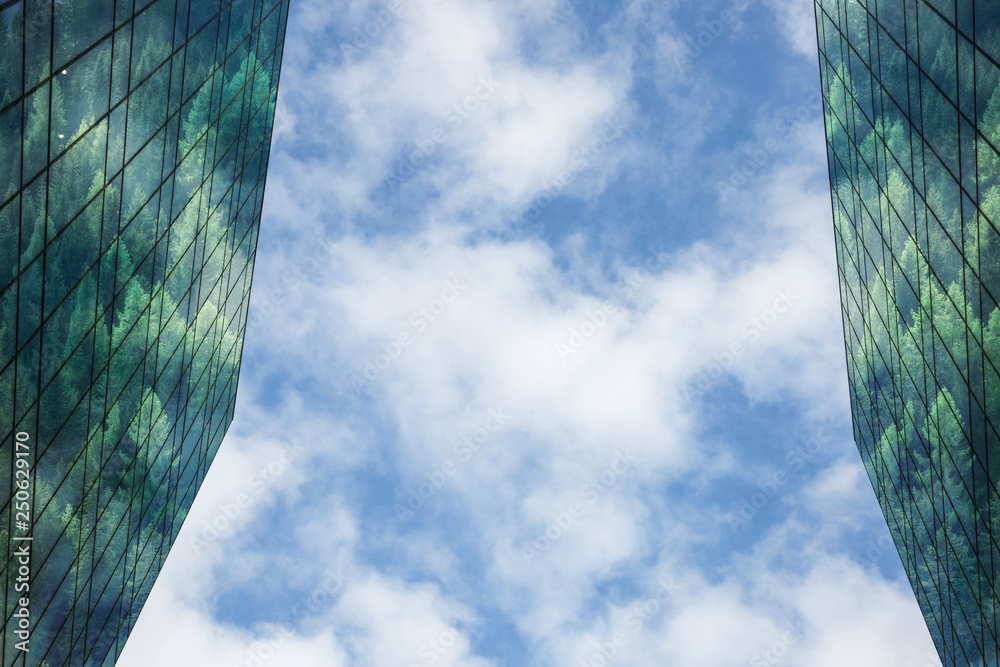 现代建筑，窗户和立面反射着森林，背景是蓝天和云朵。Susta