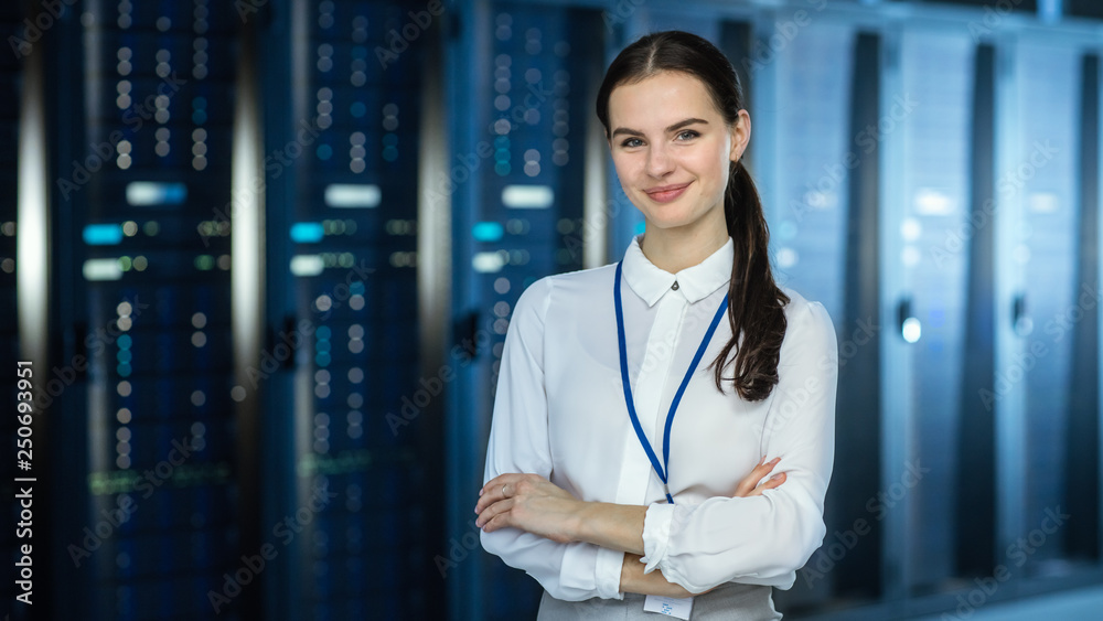 女性IT专家站在数据中心服务器机架旁边的摄像头前，看着