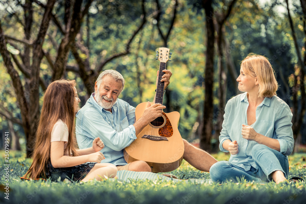 快乐的一家人在公园里一起弹吉他唱歌