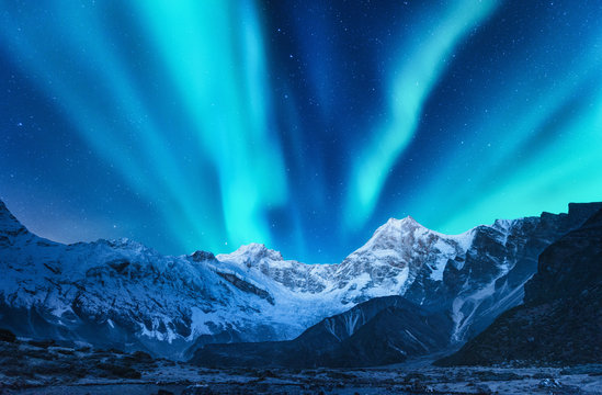 欧洲白雪皑皑的山脉上空的北极光。冬天的北极光，夜晚。