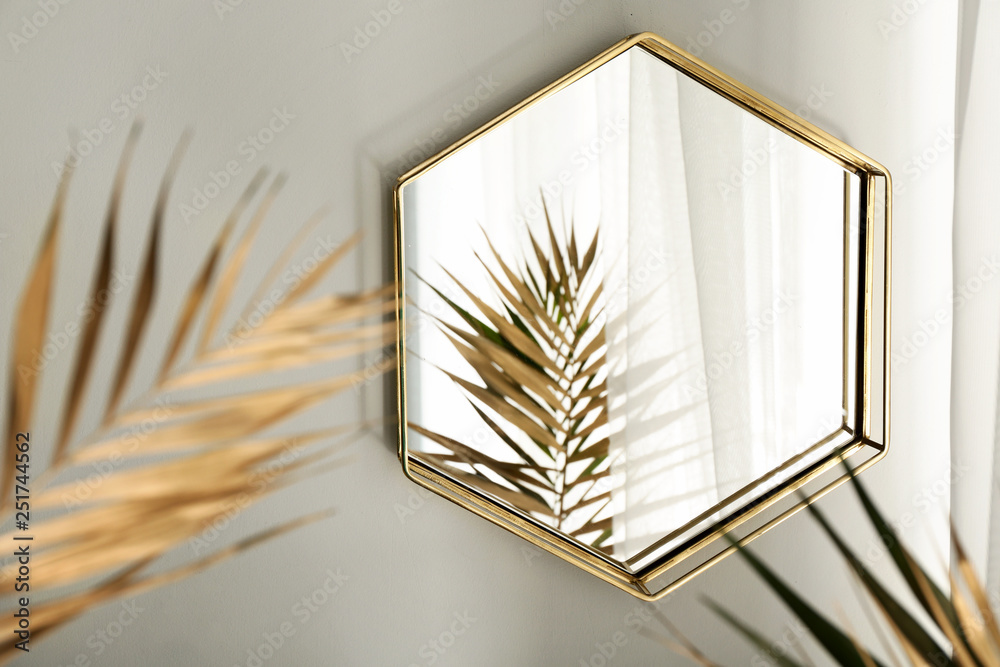 房间里的镜子和金色热带树叶