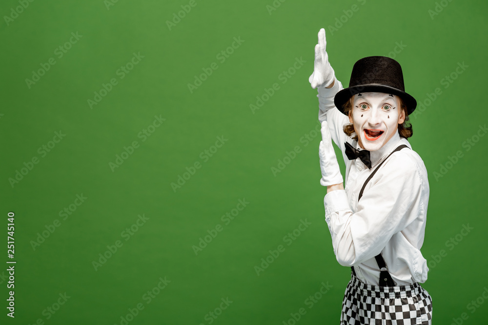Portrait of an actor as a pantomime with white facial makeup posing with expressive emotions isolate