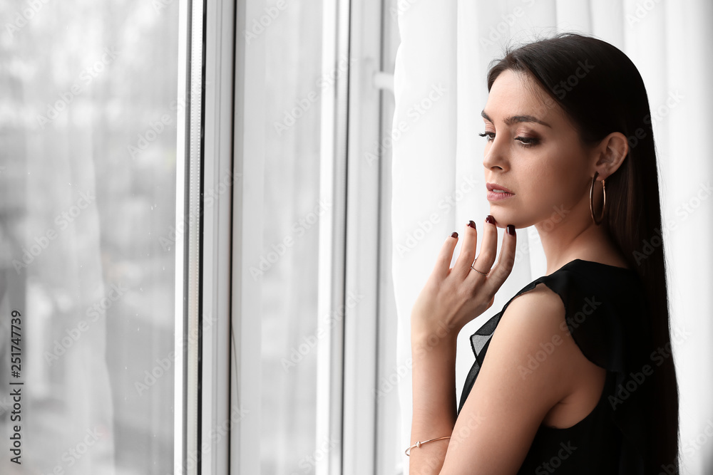 Young woman with beautiful jewelry near window