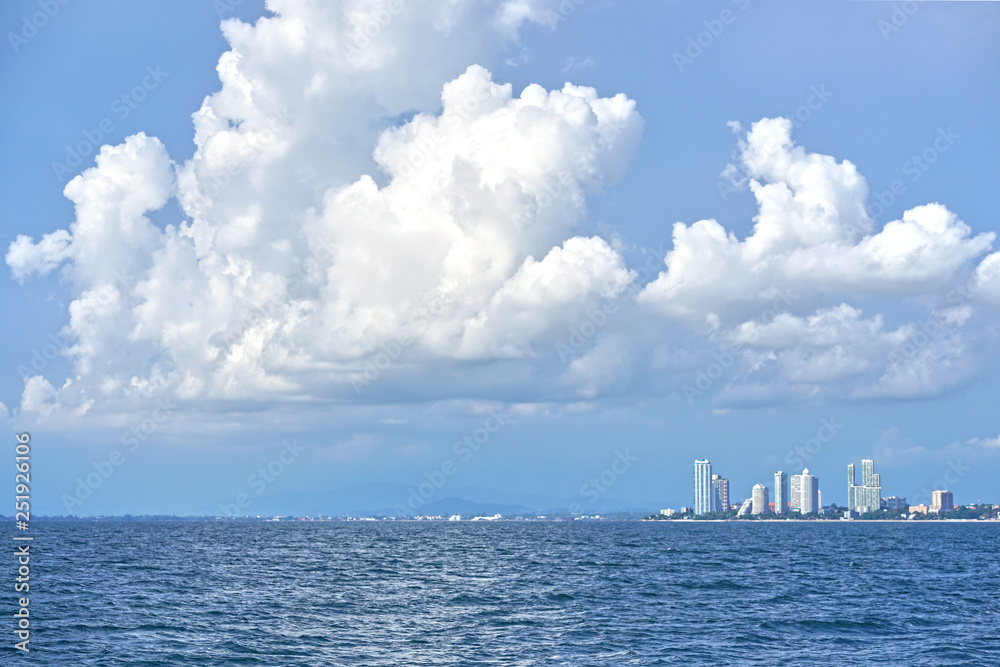 泰国芭堤雅市海面上的白色大积云和建筑物。白天可见。