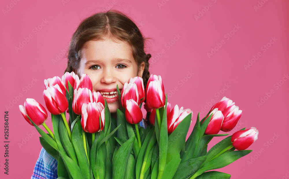粉红色背景上有一束花的有趣的小女孩
