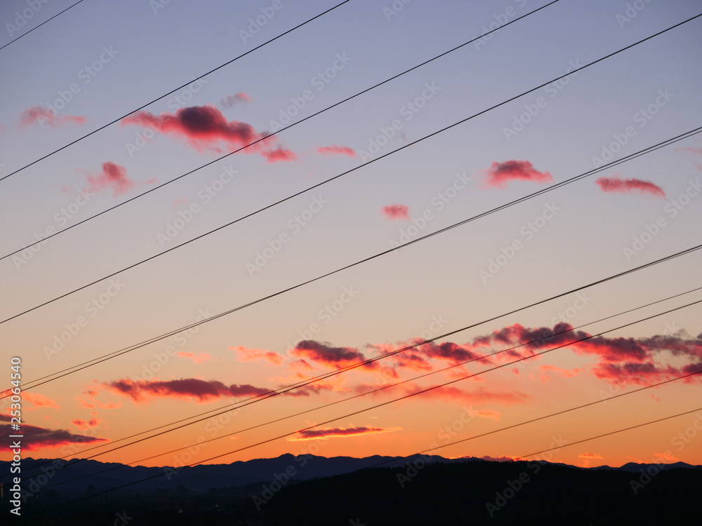 特写：丑陋的电线穿过五颜六色的秋夜天空。