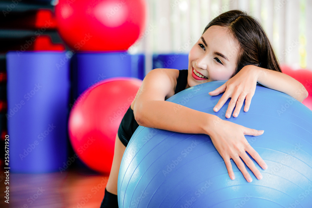 健身中心美女用健身球做普拉提运动。健康的生活方式
