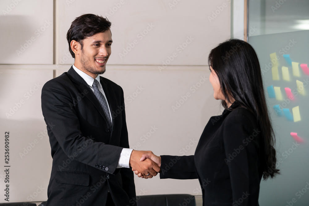 商务人士协议概念。商务人士和亚洲女商务人士在办公室握手。