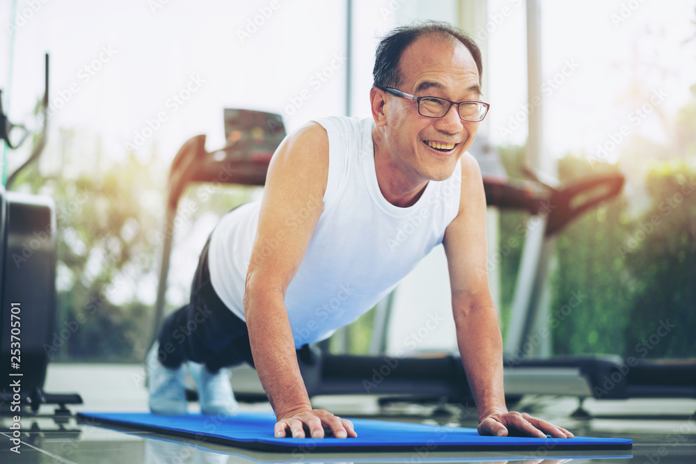 老年人在健身馆做俯卧撑。成熟健康的生活方式。