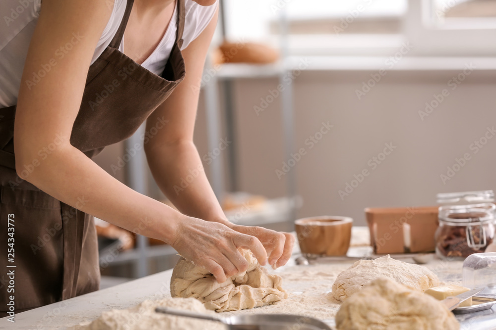 女面包师在厨房做面团