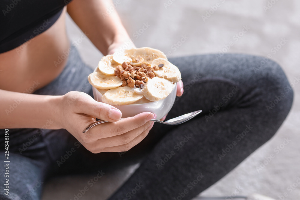 运动型女性在家吃美味酸奶，特写镜头