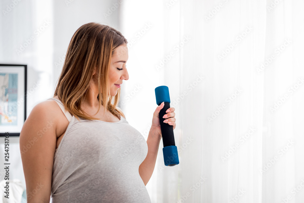 孕妇在家用哑铃锻炼