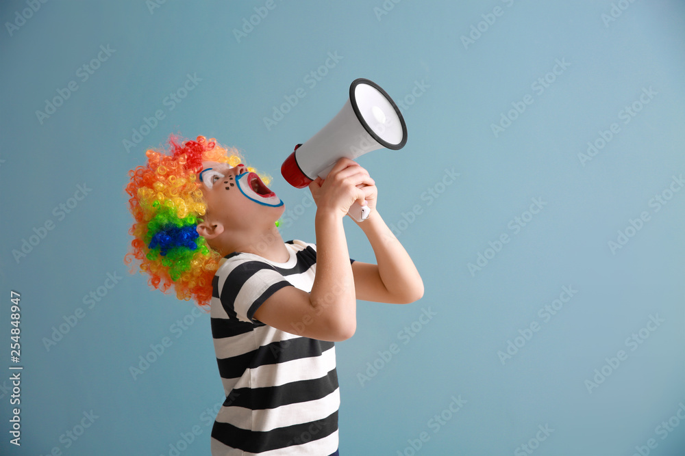 Cute little boy with clown makeup and megaphone on color background. April fools day celebration