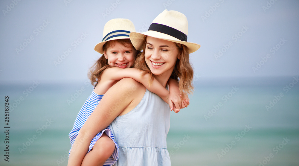 海滩上的幸福家庭。母亲和孩子女儿在海上拥抱。