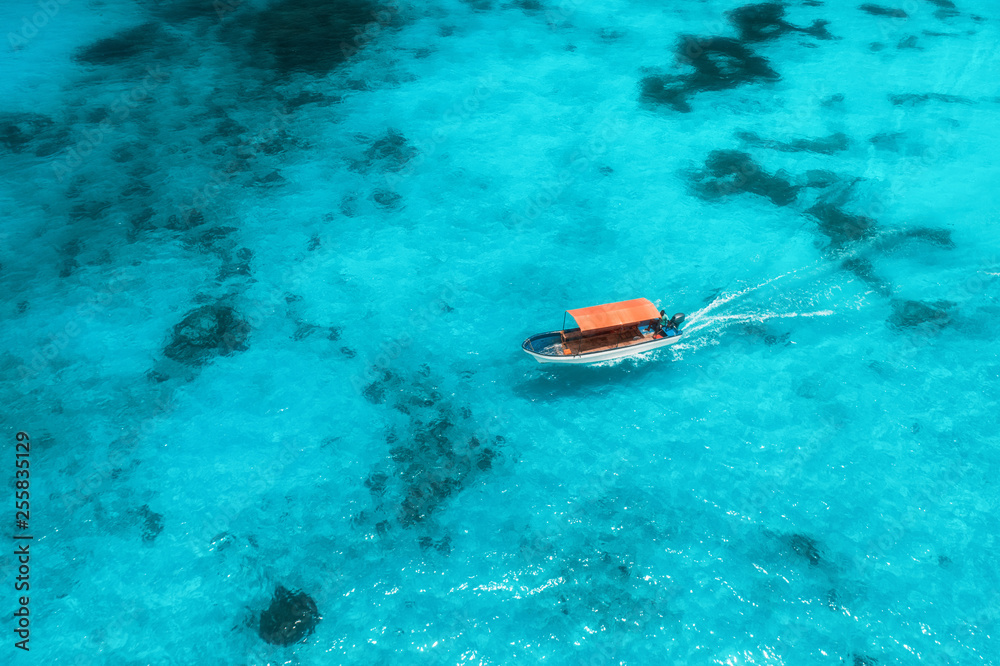 夏日阳光明媚时，透明蓝色水中的渔船鸟瞰图。大锅俯视图