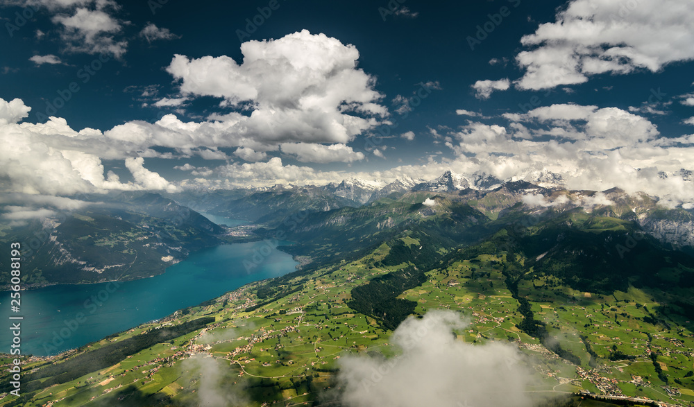 Aerial shot of Bernese Alps, lush valley and Lake Thun, Berner Oberland, Switzerland.