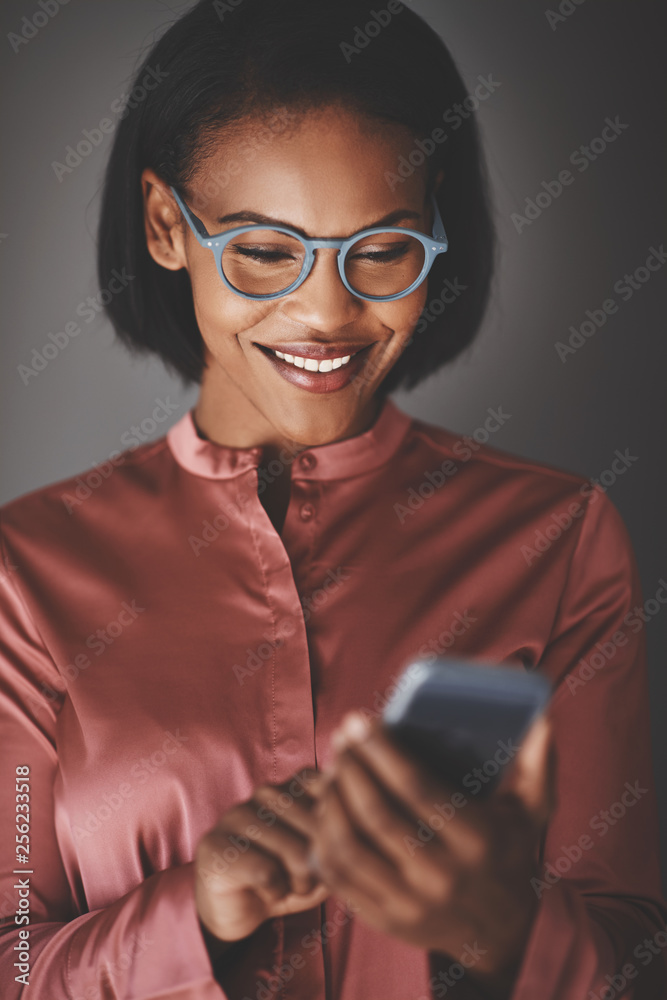 微笑的非洲女商人在灰色背景下使用手机