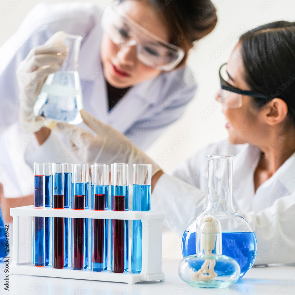 一群穿着实验室外套的科学家在实验室工作，检查实验室的生物化学样本