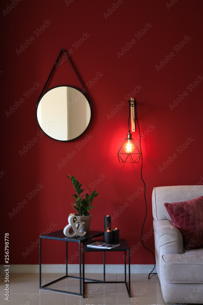 Stylish interior of room with new lamp on color wall