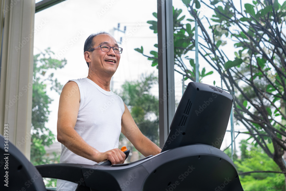 老年人在健身中心的跑步机上锻炼。成熟健康的生活方式。