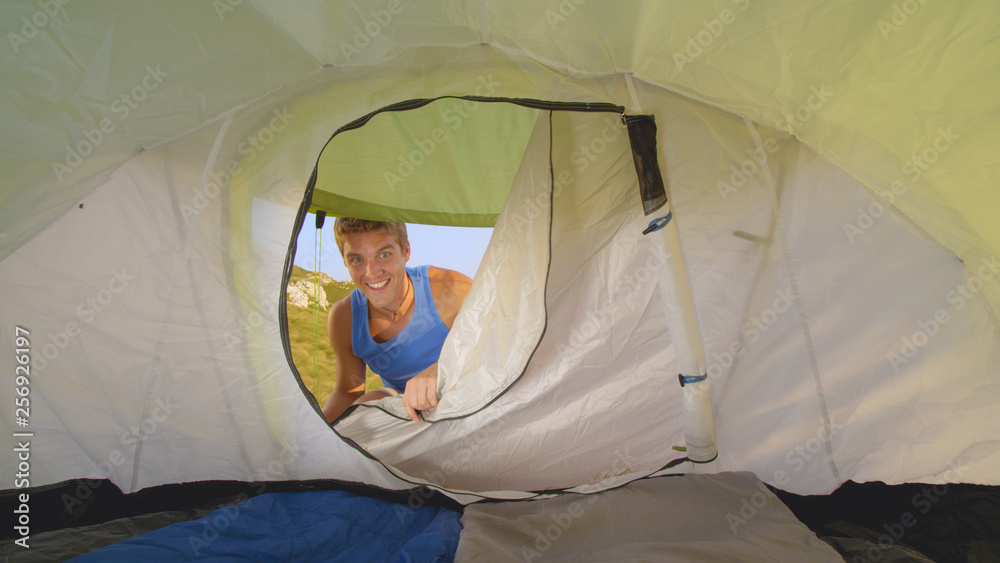 特写：兴高采烈的男性游客打开帐篷，在户外探险时进入