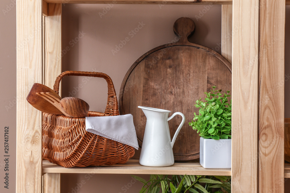 厨房彩色墙附近有木制餐具和水壶的架子