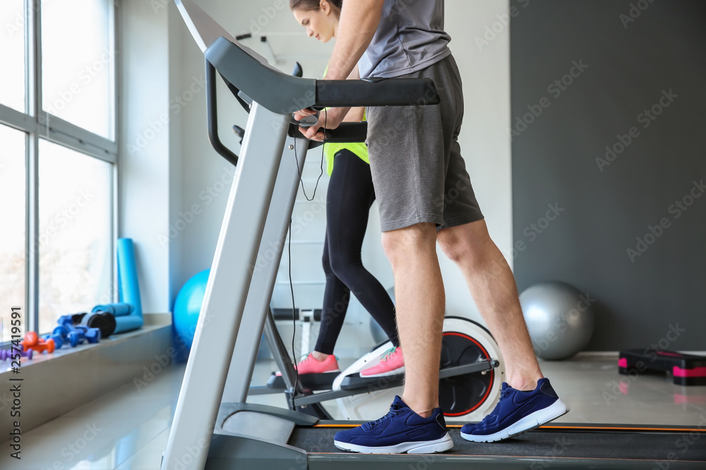运动型年轻人在健身房跑步机上训练