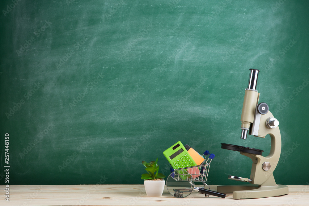 教育理念——礼堂桌子上的显微镜，黑板背景