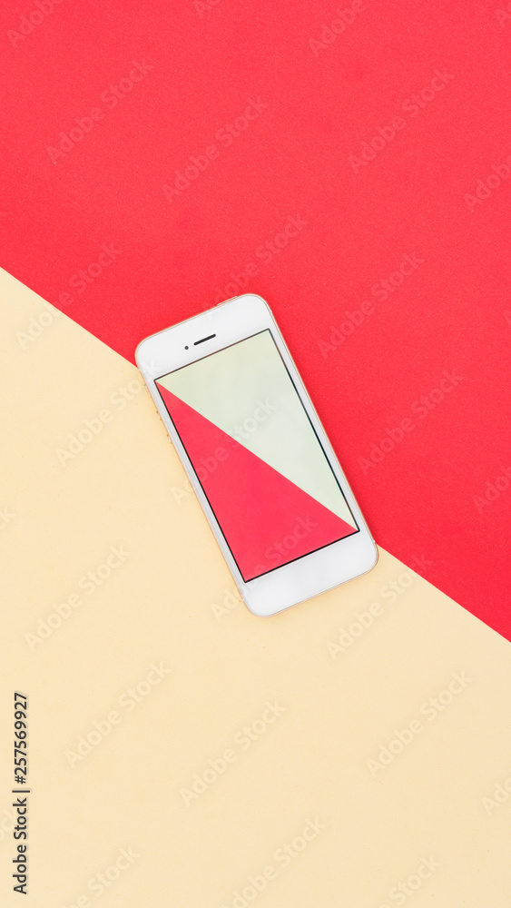 Phone on red and yellow color matching background paper