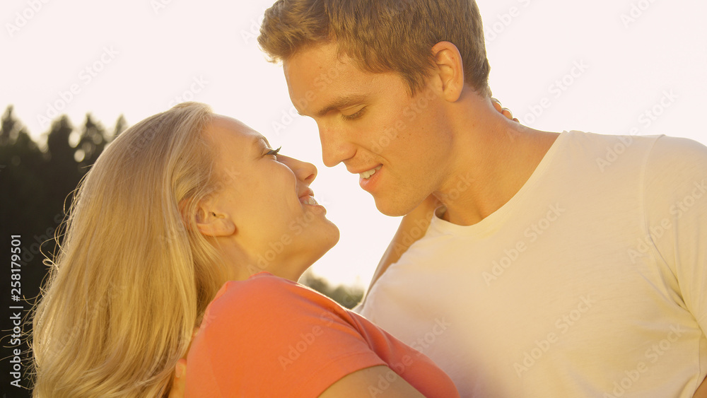 特写：英俊的男人和美丽的女人在接吻前微笑并闭上眼睛。