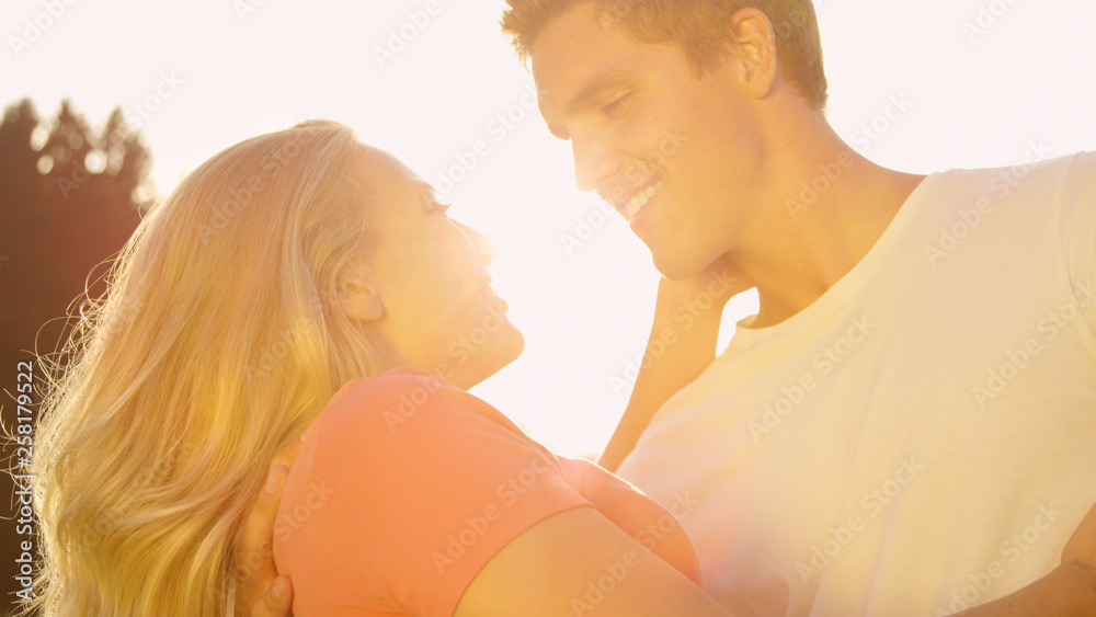 太阳耀斑：女人和男人拥抱着站着，看着对方的眼睛。