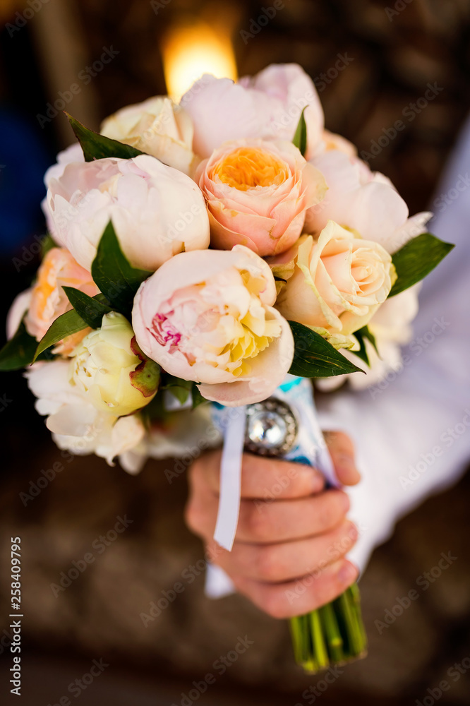 Beautiful bouquet with delicate flowers. Wedding flowers. Bridal bouquet in male hands
