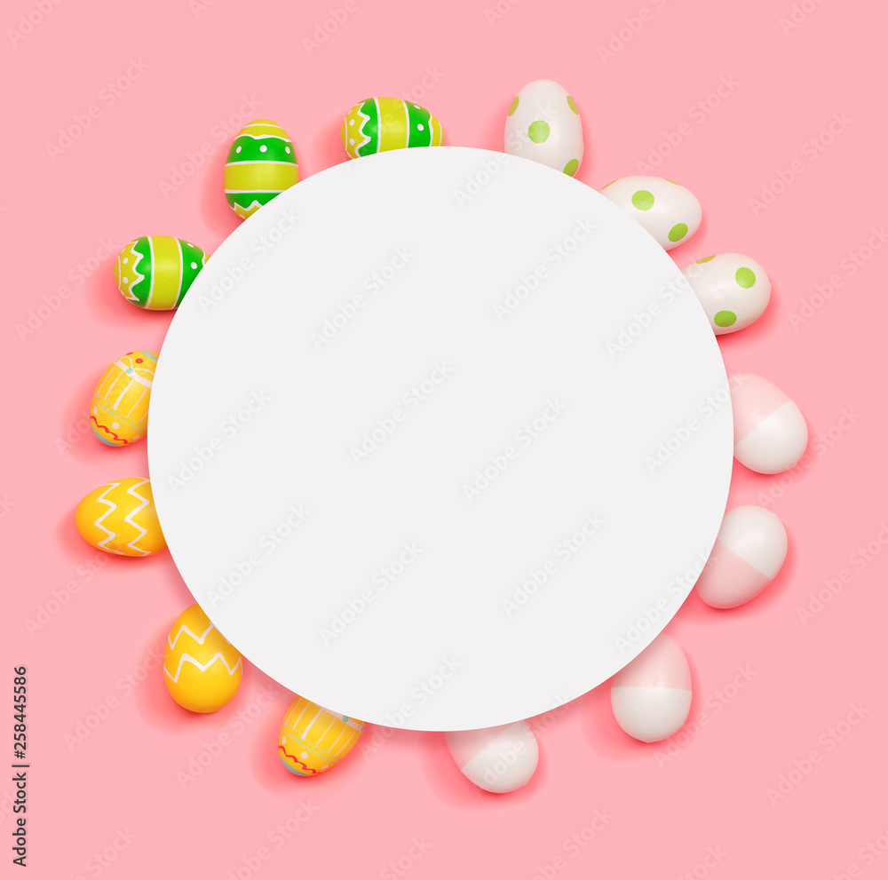 Round frame of Easter eggs with white paper overhead view flat lay