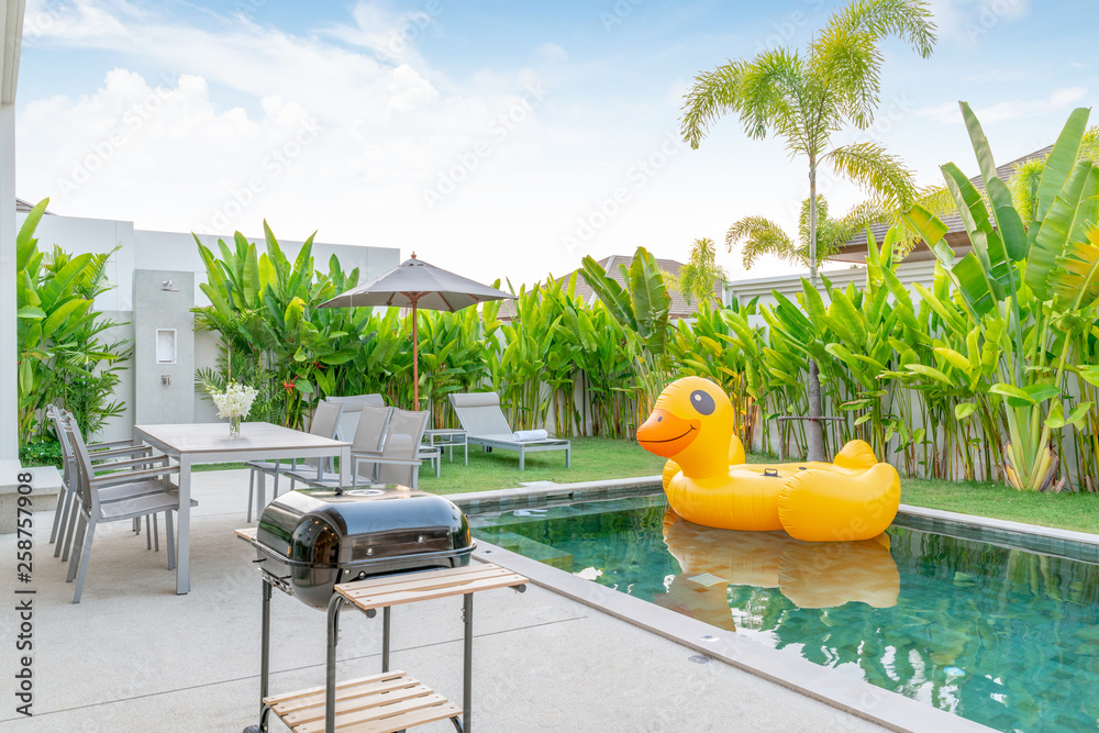 住宅或房屋外观设计，展示热带游泳池别墅，带绿色花园、阳光床和漂浮物