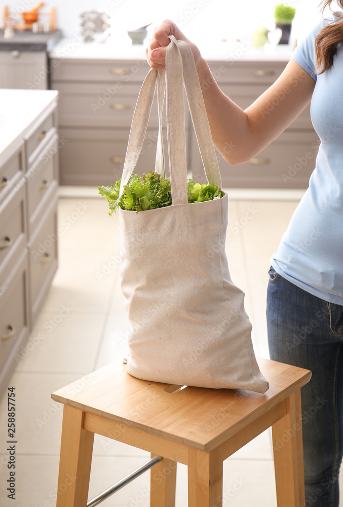 室内环保袋里装着新鲜蔬菜的年轻女子